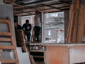man in white dress shirt standing beside brown wooden table